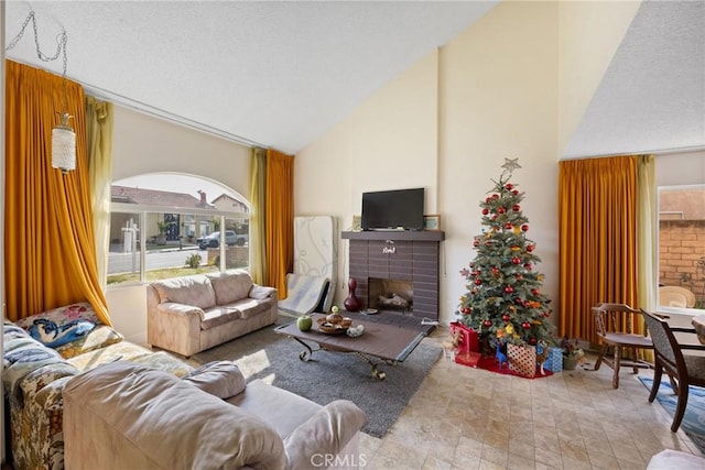 living room with a brick fireplace and high vaulted ceiling