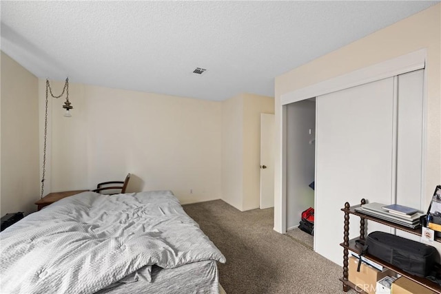 carpeted bedroom featuring a closet and a textured ceiling