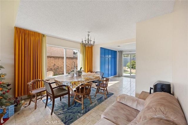 dining space featuring a chandelier, a textured ceiling, and light tile patterned floors