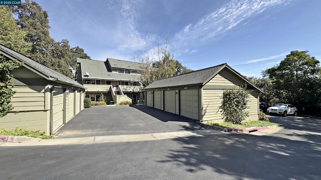 exterior space featuring a garage and an outbuilding