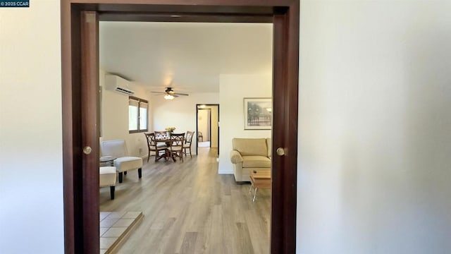 hallway featuring a wall mounted AC and light hardwood / wood-style floors