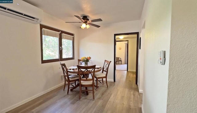 dining area with ceiling fan, light hardwood / wood-style flooring, and a wall mounted AC