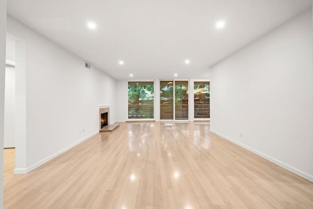 unfurnished living room with light hardwood / wood-style flooring and floor to ceiling windows