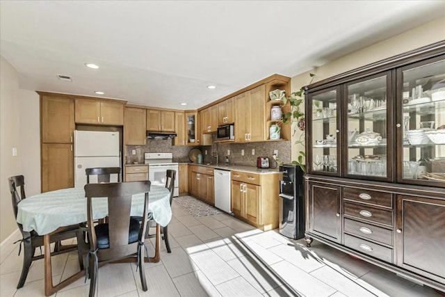 kitchen featuring sink, light tile patterned floors, white appliances, and decorative backsplash