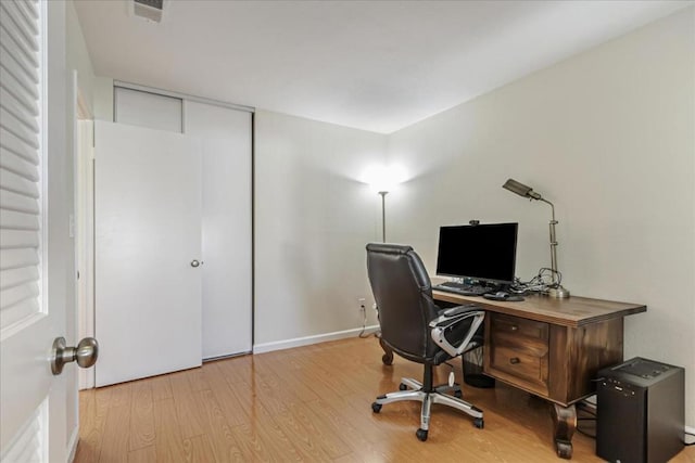 home office with light hardwood / wood-style floors