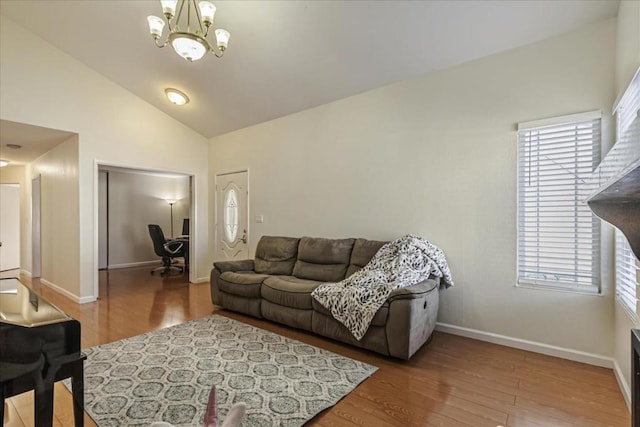 living room featuring lofted ceiling, hardwood / wood-style floors, and an inviting chandelier