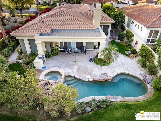 exterior space with an in ground hot tub and a patio