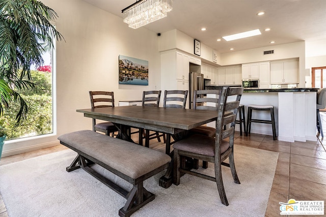 tiled dining area featuring a notable chandelier