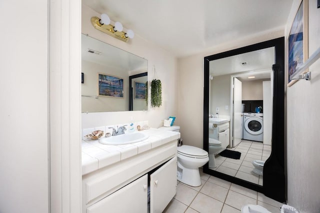 bathroom featuring toilet, tile patterned floors, washer / clothes dryer, and vanity