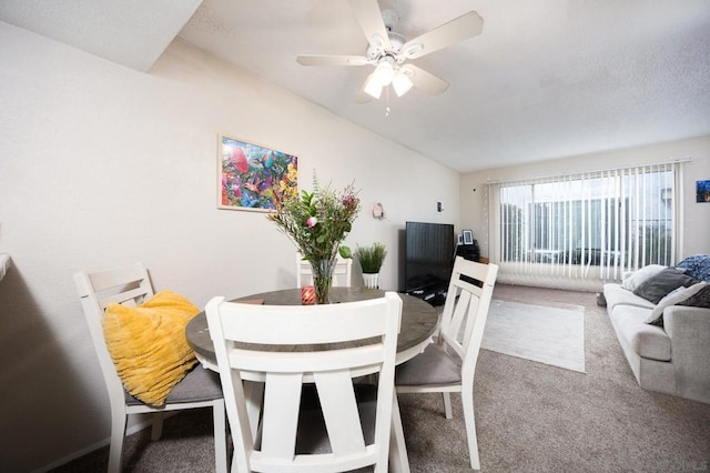 carpeted dining space with ceiling fan