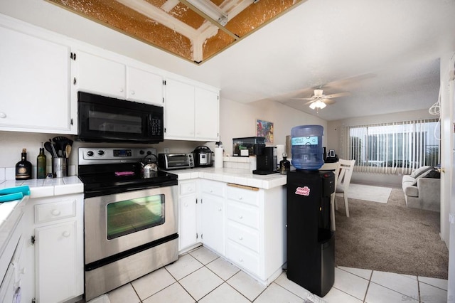 kitchen featuring stainless steel electric range, tile countertops, and white cabinets