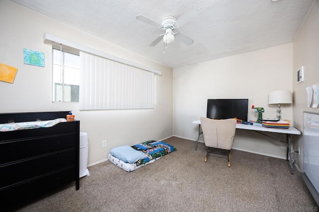 carpeted home office with ceiling fan and a textured ceiling