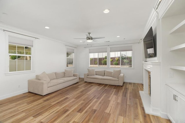 unfurnished living room with crown molding, ceiling fan, and light hardwood / wood-style floors