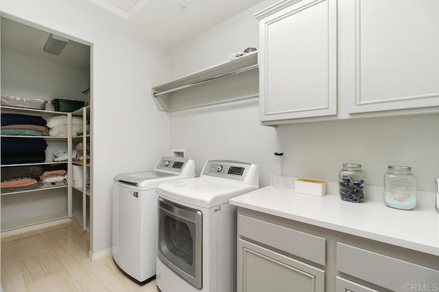 washroom with cabinets and washer and dryer