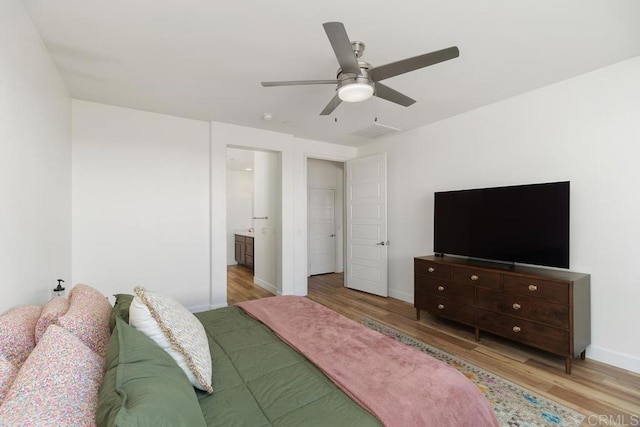 bedroom with ceiling fan, ensuite bathroom, and light hardwood / wood-style flooring