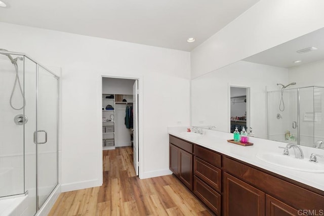 bathroom featuring vanity, hardwood / wood-style flooring, and a shower with shower door