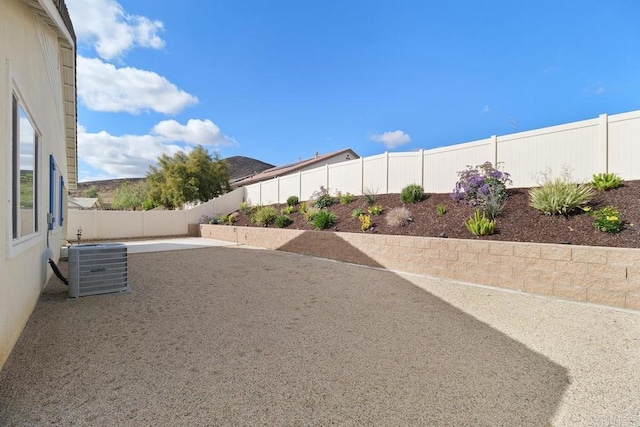 view of yard with central AC unit and a patio area