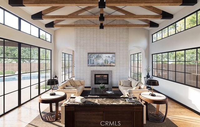 living room featuring high vaulted ceiling, a fireplace, light hardwood / wood-style floors, and plenty of natural light