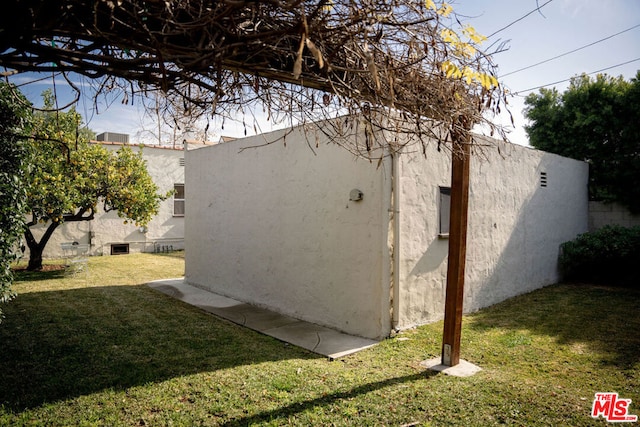 view of side of home with a yard