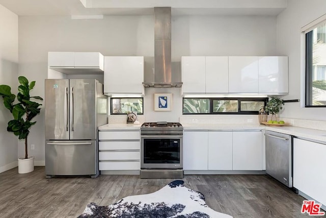 kitchen featuring dark hardwood / wood-style flooring, island range hood, stainless steel appliances, and white cabinets