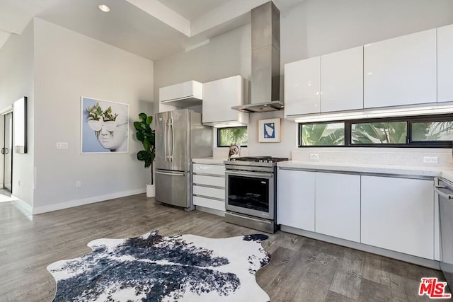 kitchen featuring white cabinets, dark hardwood / wood-style floors, wall chimney exhaust hood, and appliances with stainless steel finishes