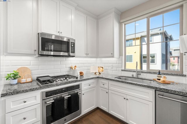 kitchen with stainless steel appliances, white cabinetry, and sink