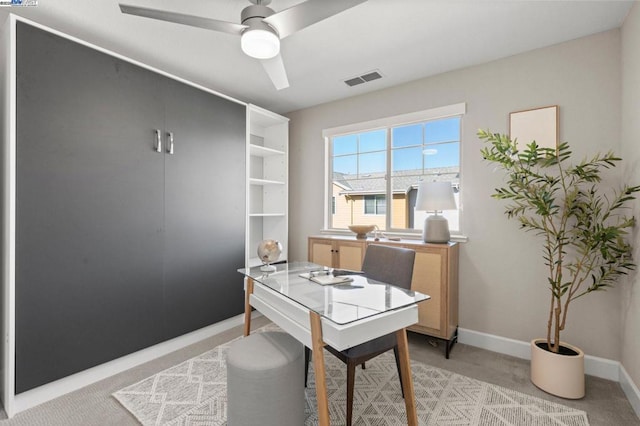 carpeted home office featuring ceiling fan