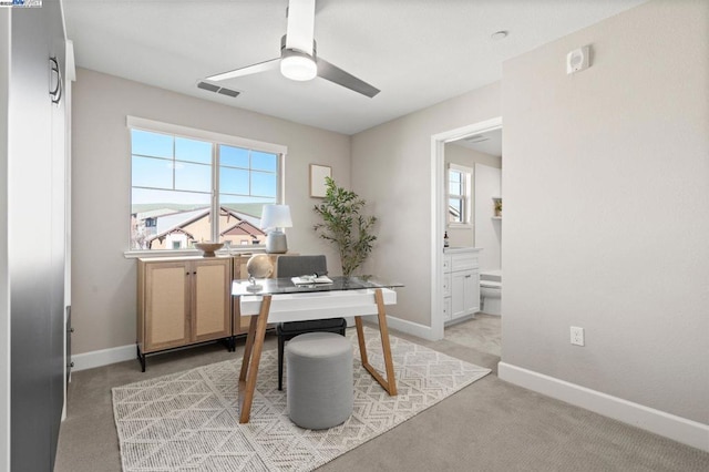 carpeted office space featuring ceiling fan