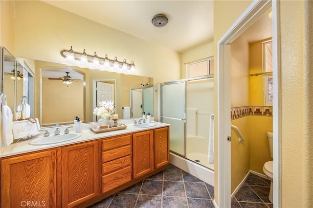 bathroom with vanity, ceiling fan, a shower with door, and toilet