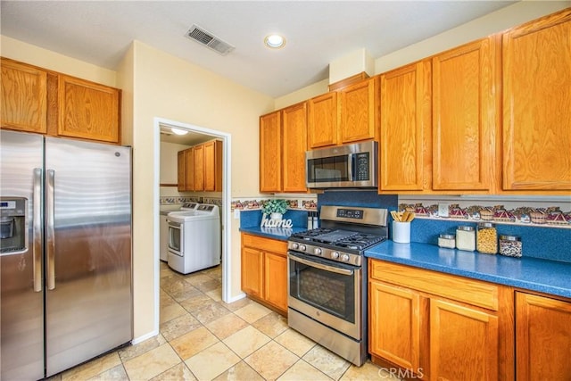 kitchen featuring washing machine and clothes dryer and stainless steel appliances