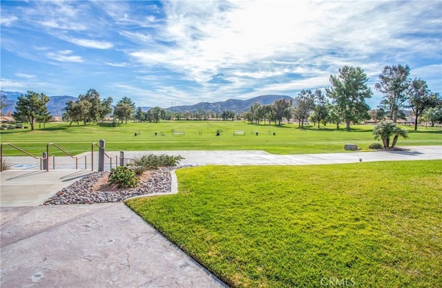 view of property's community with a mountain view and a lawn