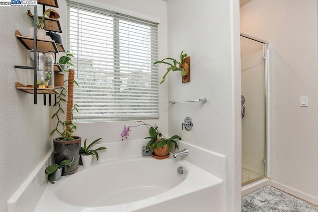 bathroom featuring shower with separate bathtub