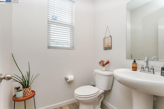 bathroom with hardwood / wood-style flooring, toilet, and sink