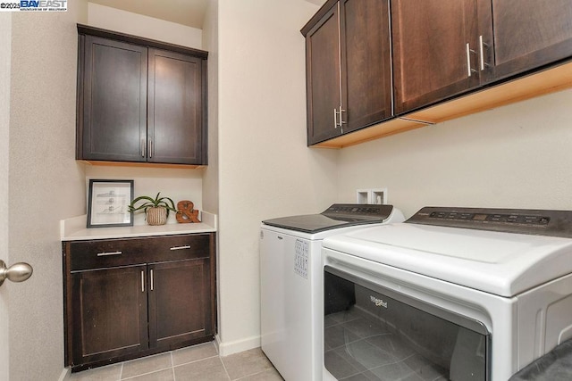 clothes washing area featuring cabinets, light tile patterned flooring, and separate washer and dryer