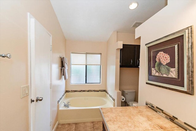 bathroom with vanity, a tub, and toilet