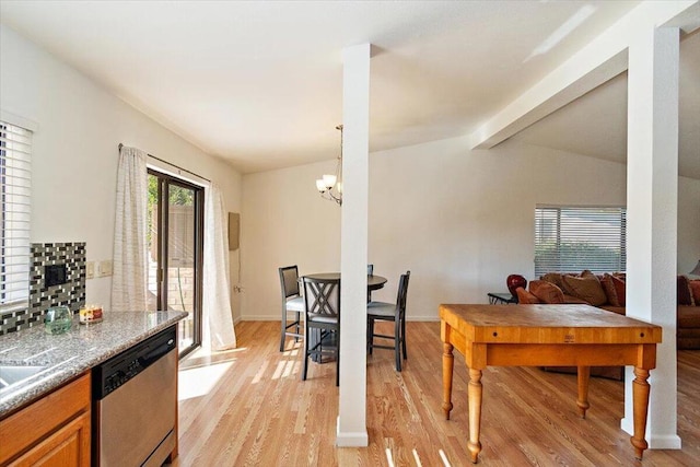 dining space with a notable chandelier, lofted ceiling with beams, and light wood-type flooring