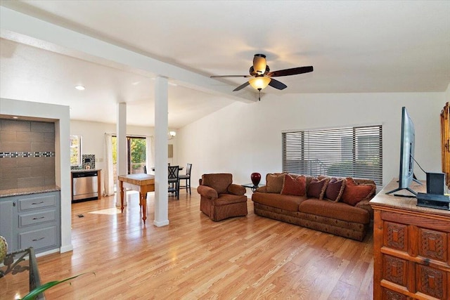 living room with ceiling fan, lofted ceiling with beams, and light wood-type flooring