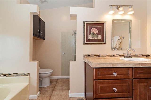 bathroom with tile patterned flooring, vanity, a bath, tasteful backsplash, and toilet