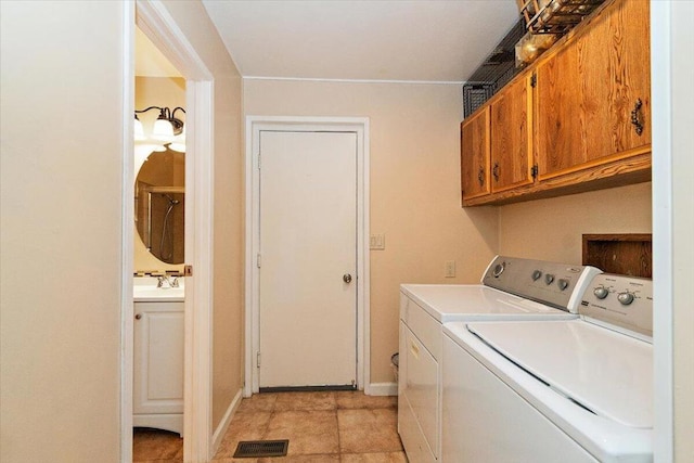 clothes washing area featuring cabinets, sink, and independent washer and dryer