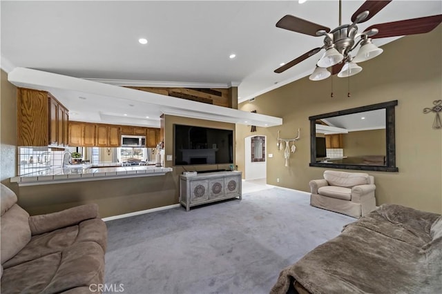 living room featuring vaulted ceiling, ornamental molding, light colored carpet, and ceiling fan