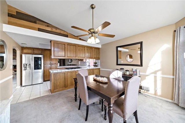 dining area featuring light carpet, lofted ceiling, and ceiling fan