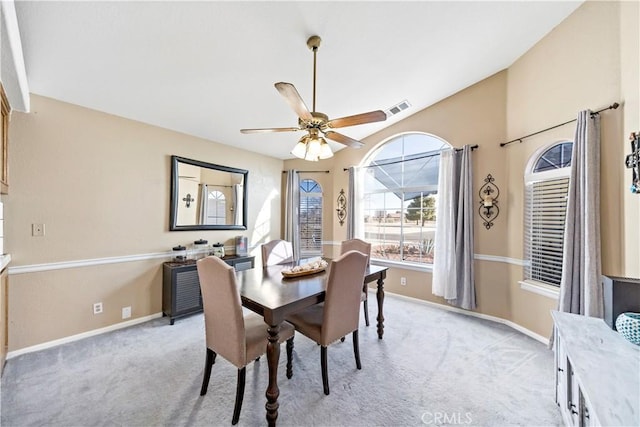 dining space with light carpet and ceiling fan