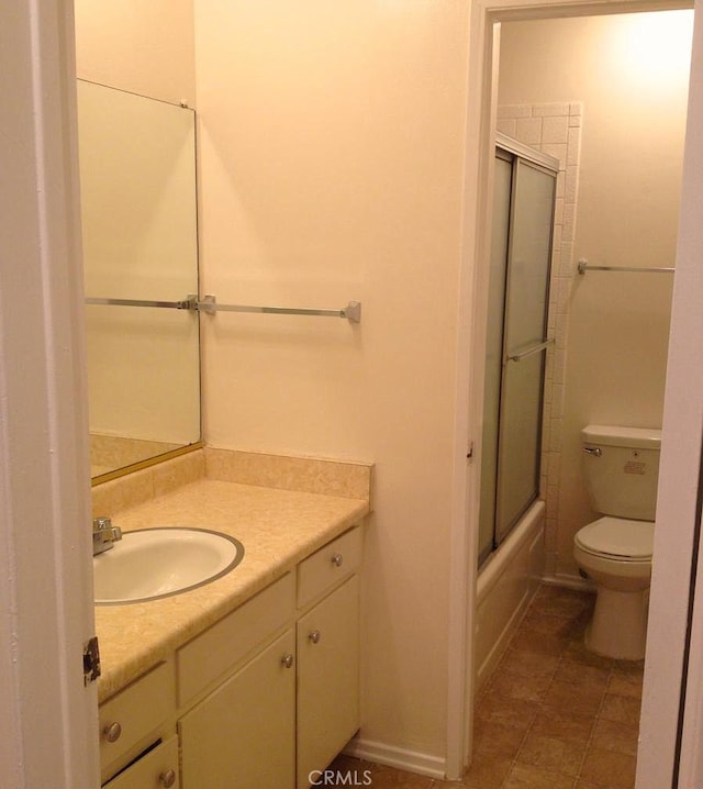 full bathroom with enclosed tub / shower combo, vanity, tile patterned floors, and toilet