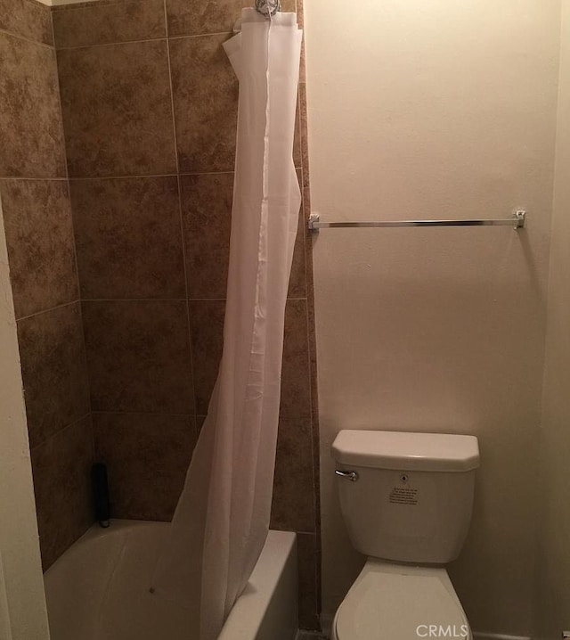 bathroom featuring shower / bathtub combination with curtain and toilet