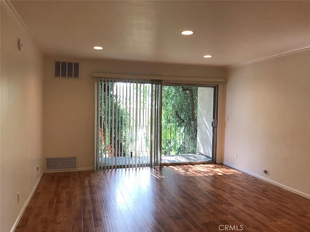 empty room featuring crown molding and dark hardwood / wood-style flooring