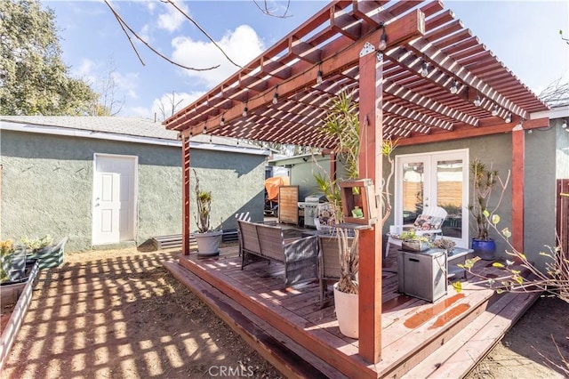 wooden deck featuring a pergola and french doors