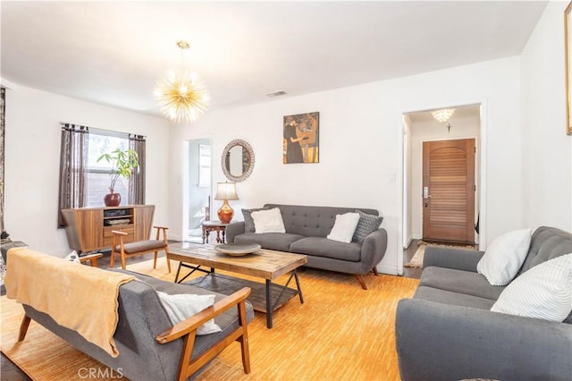 living room featuring light wood-type flooring and a notable chandelier