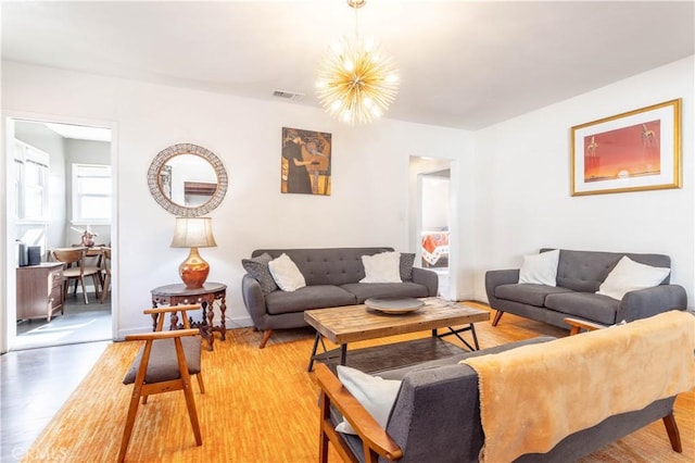 living room with an inviting chandelier and hardwood / wood-style flooring