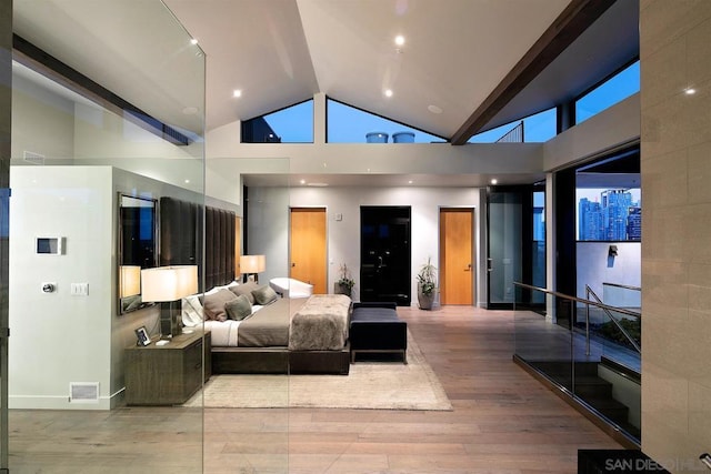 bedroom with light hardwood / wood-style flooring and high vaulted ceiling