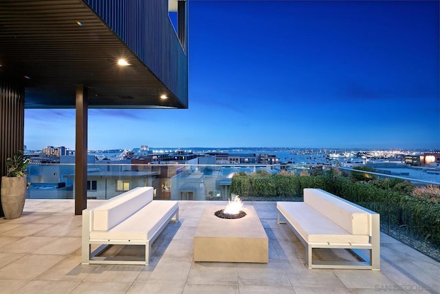 patio terrace at dusk featuring an outdoor fire pit